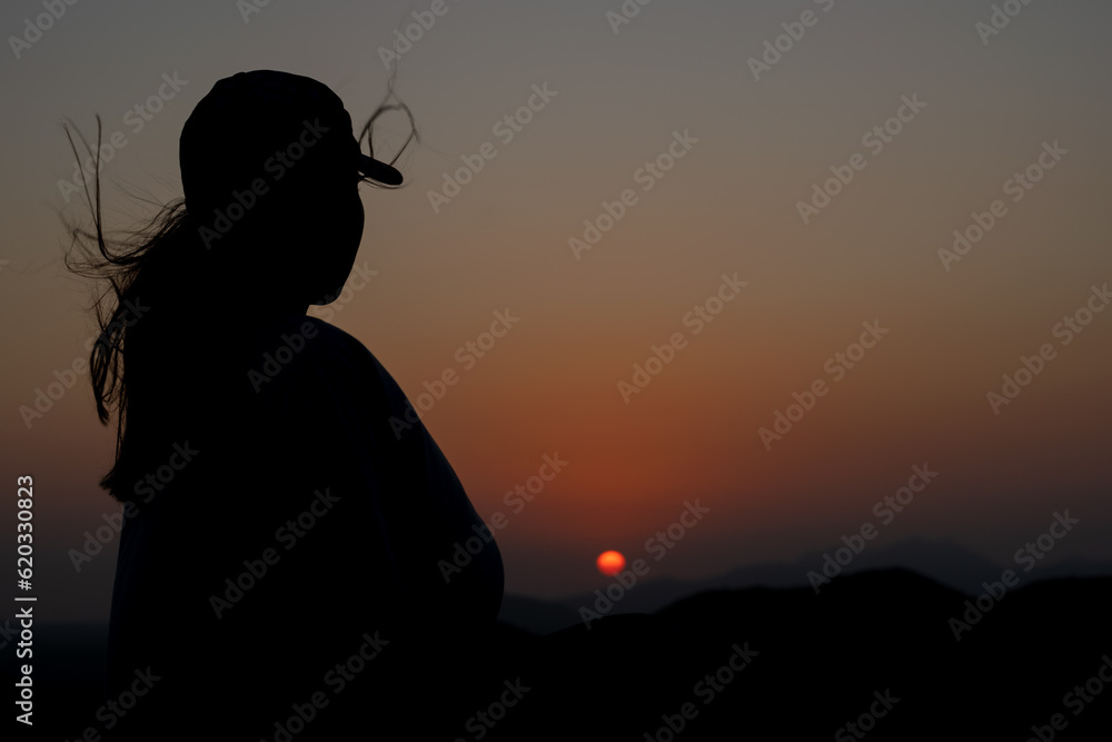 Wall mural a silhouette contemplating the sunset