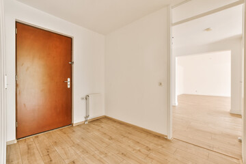 an empty room with wood flooring and white walls the door is open on the right side, to the left