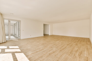 an empty living room with wood floor and sliding glass door leading to the balcony area in this...