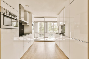 a modern kitchen with white cabinets and wood flooring in the middle of the room, looking into the dining area