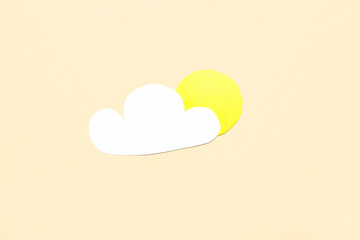Paper cloud with sun on beige background. Weather forecast concept