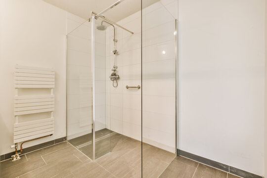 a modern bathroom with white walls and tile flooring, including a walk - in shower stall on the right side