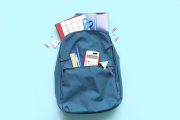 Naklejka premium School backpack with different stationery on blue background