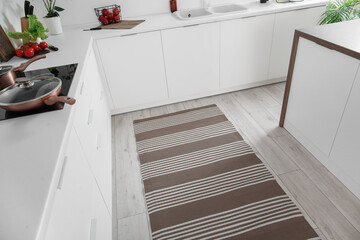 Stylish striped rug in interior of modern kitchen