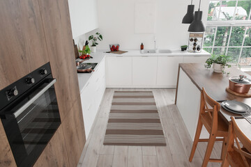 Stylish striped rug in interior of modern kitchen