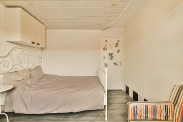 Fototapeta na wymiar a bedroom with a bed, chair and wallpapers on the walls in this photo is taken from above