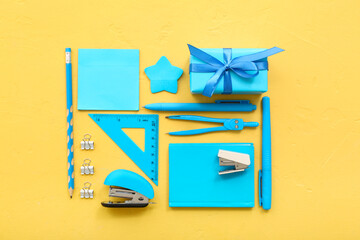 Fototapeta na wymiar Gift box with different stationery on yellow background