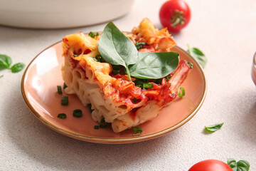 Plate of pasta with tomato sauce and cheese on grey background