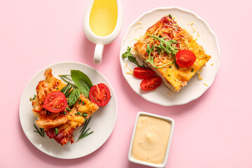 Plates of pasta with tomato sauce and cheese on pink background