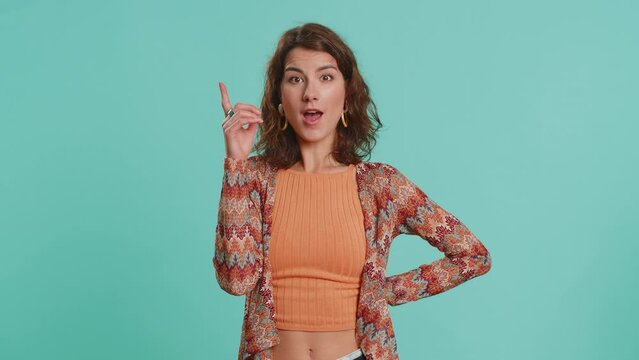 Eureka. Inspired young woman pointing finger up with open mouth, having good idea plan startup, showing inspiration motivation gesture, problem solution. Pretty girl isolated on blue background