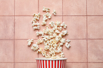 Bucket with tasty popcorn on pink tile background