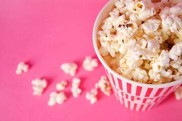 Fototapeta na wymiar Bucket with tasty popcorn on pink background