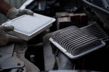 The master changes the air filter in the car engine. 