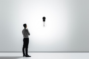 Obraz premium a concept art of a business man looking at a light bulb symbolizing a new creative idea eureka. isolated on white background. Generative AI