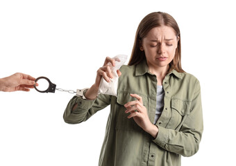 Young female junkie with drugs and handcuffs on white background