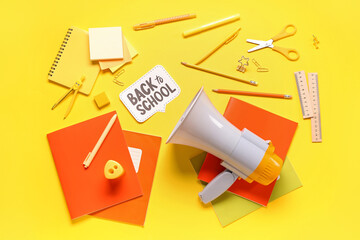 Different stationery, megaphone and speech bubble with text BACK TO SCHOOL on yellow background