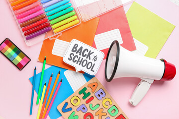 Stationery, megaphone and speech bubble with text BACK TO SCHOOL on pink background