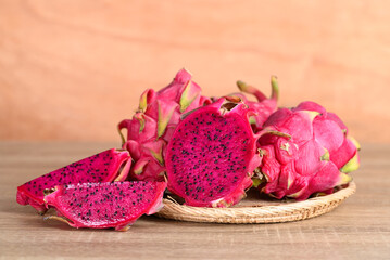 Red dragon fruit or pitaya in basket on wooden background, Tropical fruit in summer season