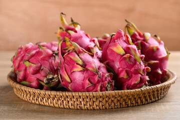 Red dragon fruit or pitaya in basket on wooden background, Tropical fruit in summer season