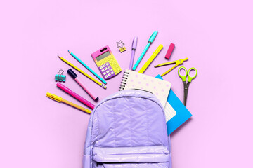 Backpack with calculators and different stationery on lilac background