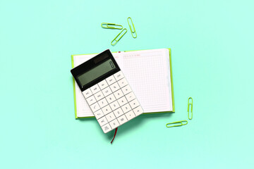 Modern calculator with stationery on turquoise background