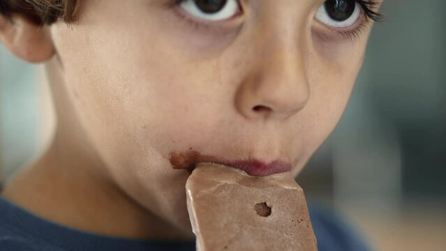 Child mouth covered with chocolate icecream. Little boy taking a bite of ice cream sweet dessert
