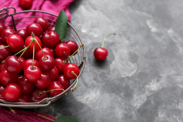 Basket with fresh cherry on grey background, closeup