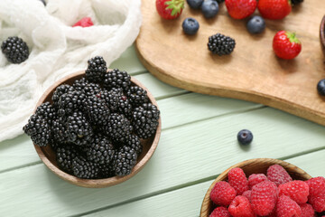 Composition with different fresh berries on color wooden background, closeup