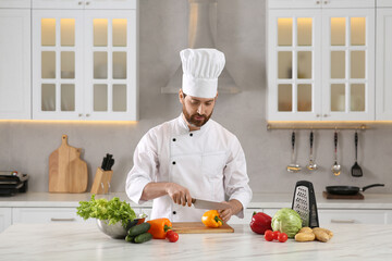Chef cutting bell pepper at marble table in kitchen