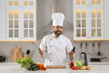 Portrait of chef with cucumber and knife at marble table in kitchen