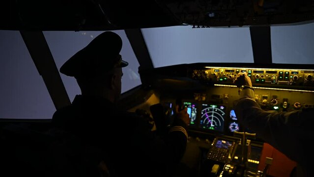 Close-up of male hands on the control panel of an airplane.