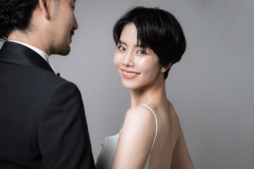 女性をエスコートする男性と振り返る美人な女性　カメラ目線