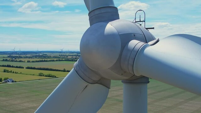 Canadian hydro wind turbine with blades spin. Windmills on the food farm generating green energy. Sustainable alternative energy. Blue sky panorama. Energy shortage, prices and crisis concept.