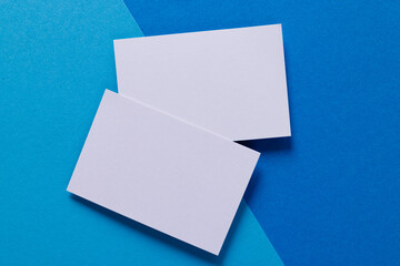 White business cards with copy space on light and dark blue background