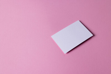 White business card with copy space on pink background