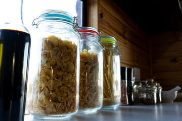 Storage jars of food on countertop in sunny kitchen in log cabin