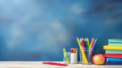 Colored pencils, colorful books and apple with chalkboard background. Back to school banner. Space for text.