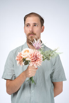 Studio photo of a man holding a bouquet of flowers