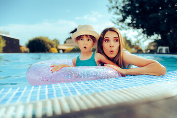 Funny Mother and Daughter Making Grimaces at the Pool. Cheerful family having fun together on...
