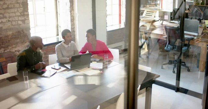 African american colleagues with laptop on table discussing work in office, slow motion