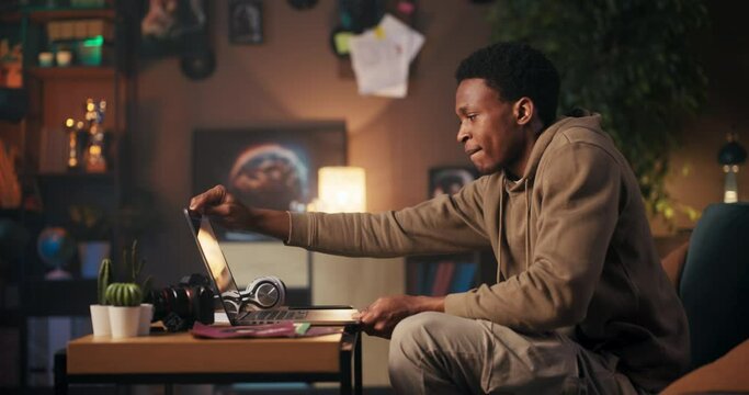 Music Producer man creating music using his computer and headphones.