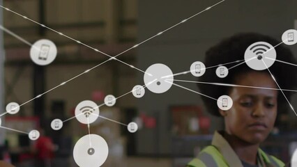 Animation of connected phone and wifi icons over african american woman and man working in warehouse - Powered by Adobe