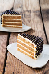 Delicious cake on plate on brown wooden table 