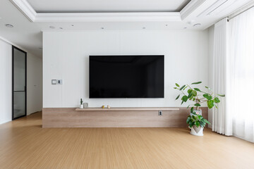 Blank modern flat screen TV hanging on wall in living room