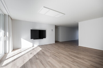 Blank modern flat screen TV hanging on wall in living room