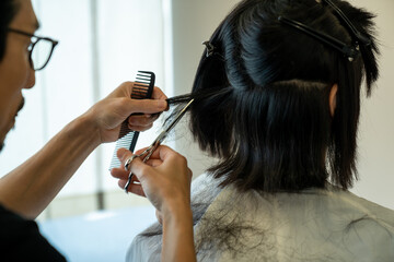 美容院でヘアカットする女性