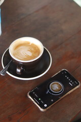 a cup of latte art on the wood