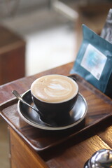 a cup of latte art on the wood