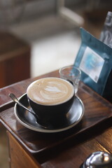 a cup of latte art on the wood