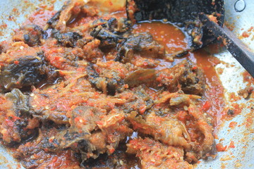 Obraz na płótnie Canvas Indonesian dish called Sambal Goreng Lele in an aluminum pan, background blur